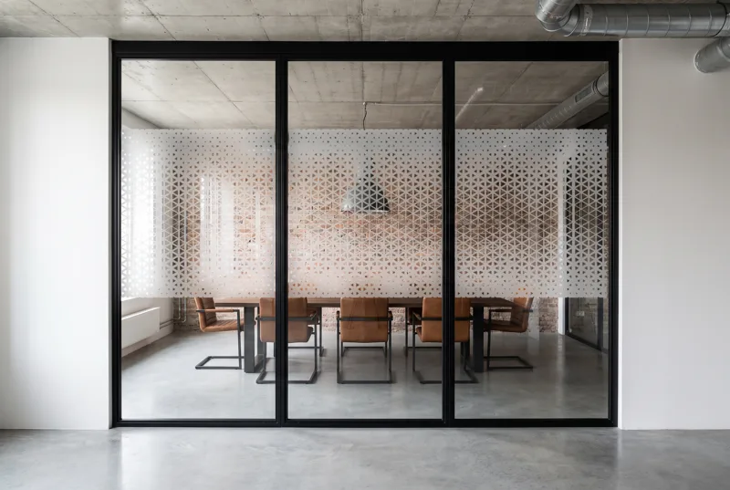 Simulation : vitrophanie Dégradé de triangles en film dépoli sur une salle de réunion de loft en brique, bande de 118 cm à l'échelle