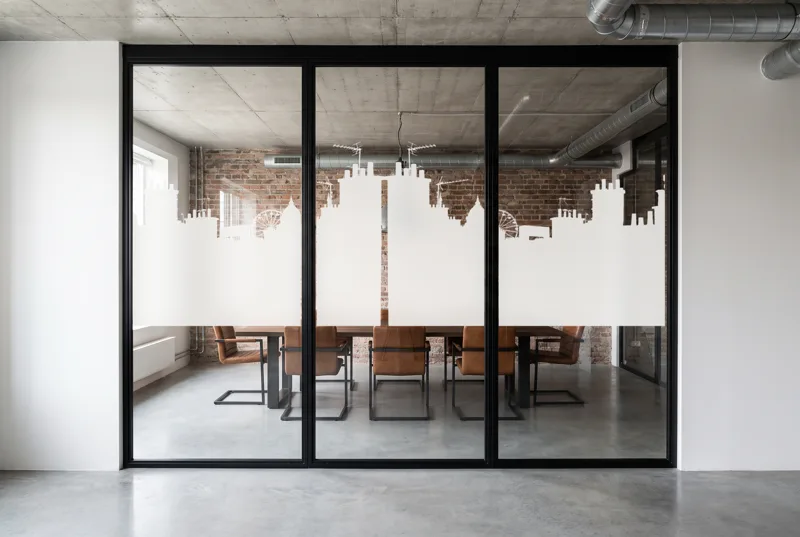 Simulation : vitrophanie Horizon Parisien en film blanc sur une salle de réunion de loft en brique, bande de 118 cm à l'échelle
