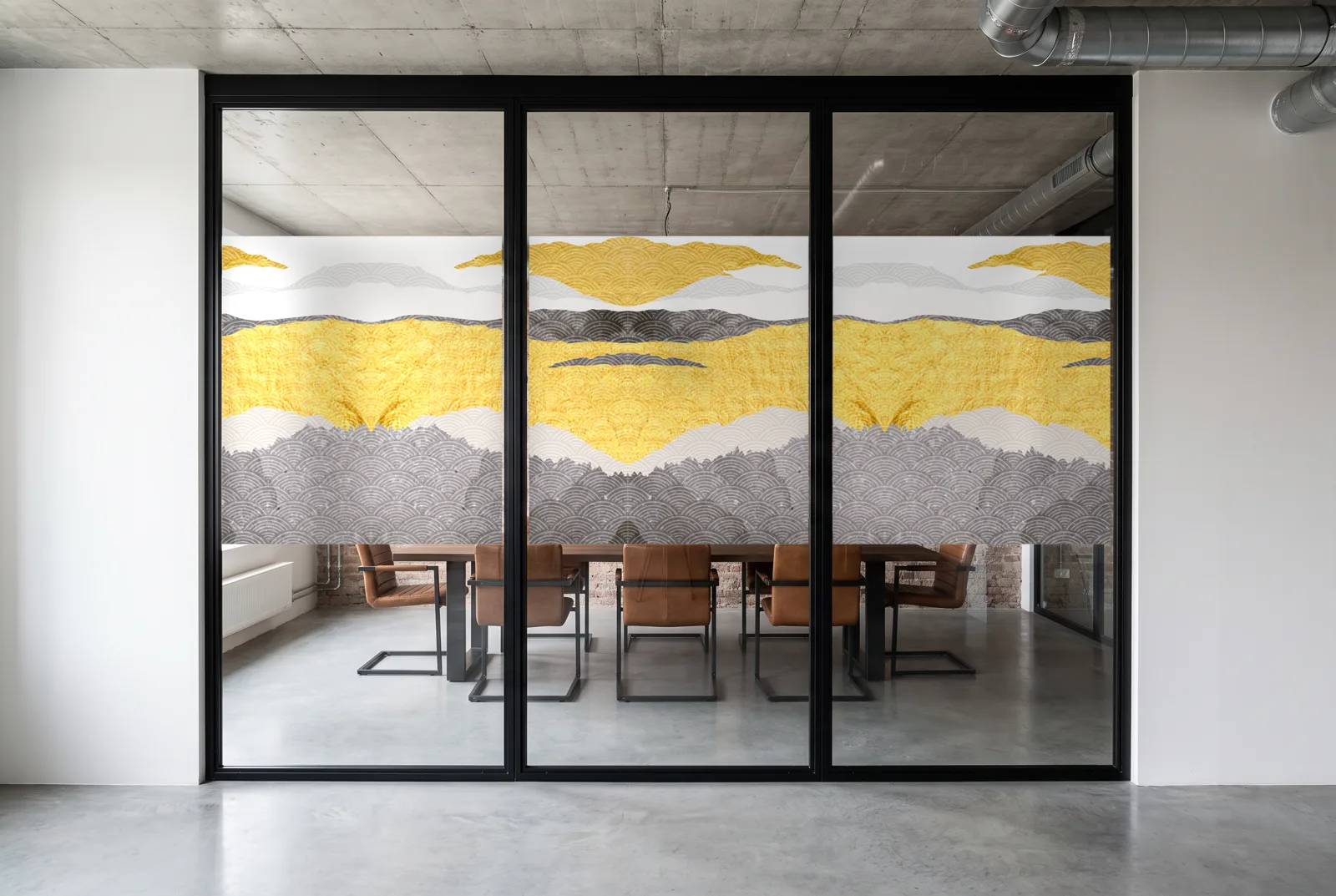 Simulation : vitrophanie Montagnes 03 en impression couleur sur une salle de réunion de loft en brique, bande de 118 cm à l'échelle