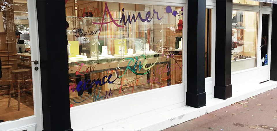 Vitrine Arthus-Bertrand décorée pour les fêtes, lettrage manuscrit sur le vitrage