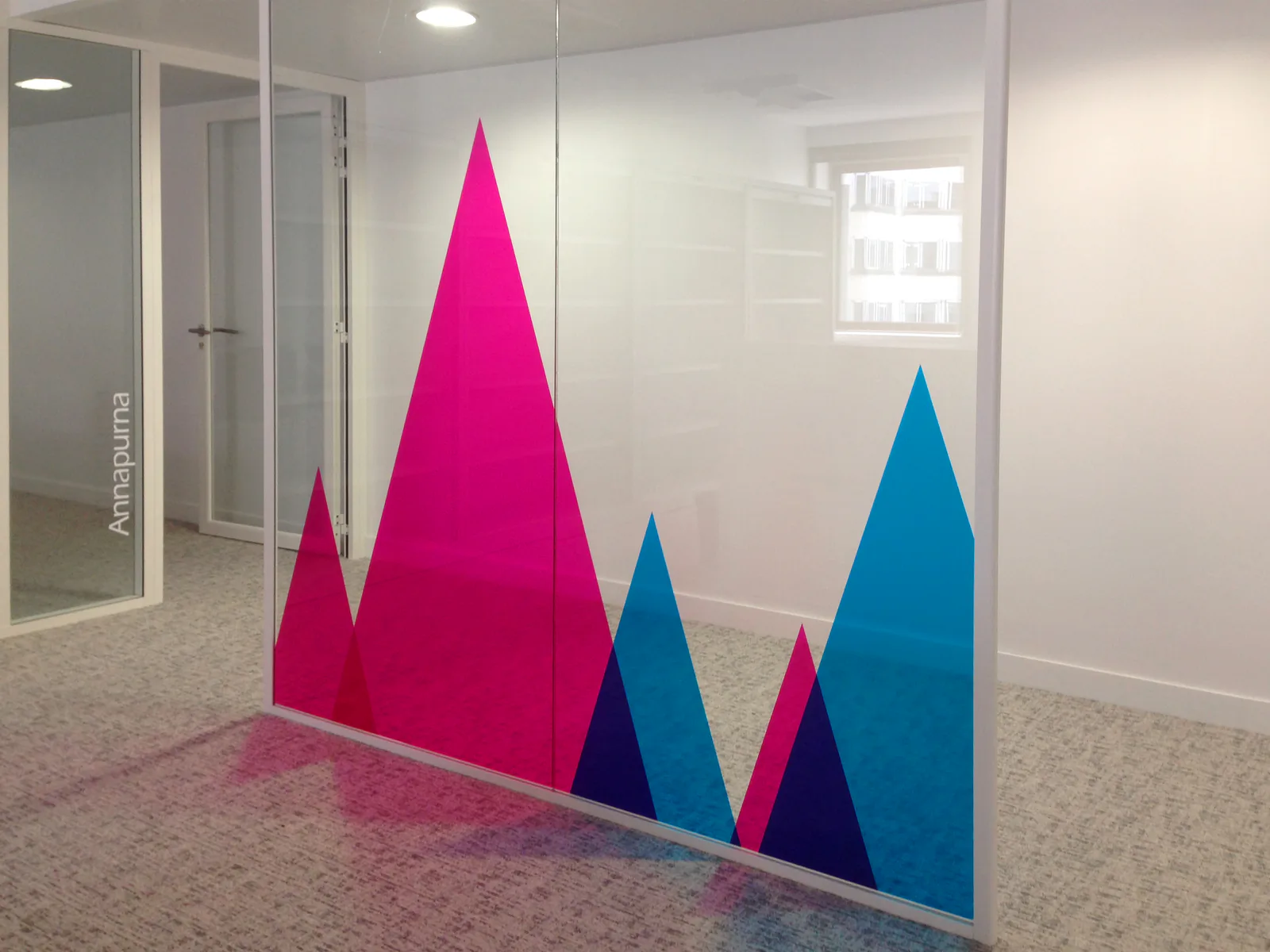 Cloisons vitrées de bureaux à La Défense habillées de montagnes graphiques colorées